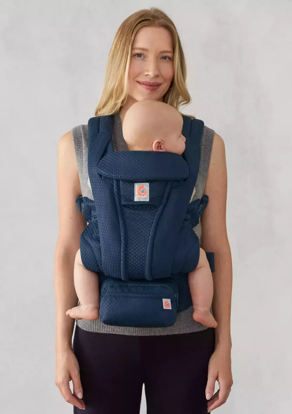 Frau trägt ihr Baby in der Ergobaby Babytrage 'Omni Deluxe' Mesh Midnight Blue (Fronttrageweise)