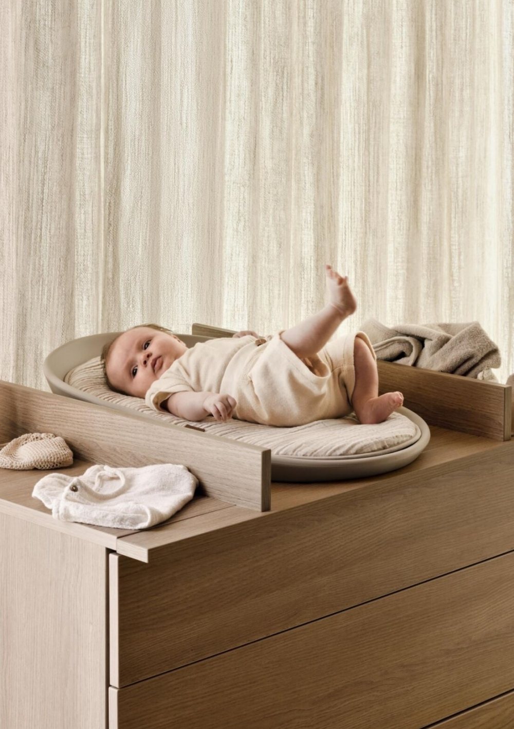 Baby liegt auf Quax Wickelkommode Kyo mit Wickelauflage 'Mamee' und Inlay