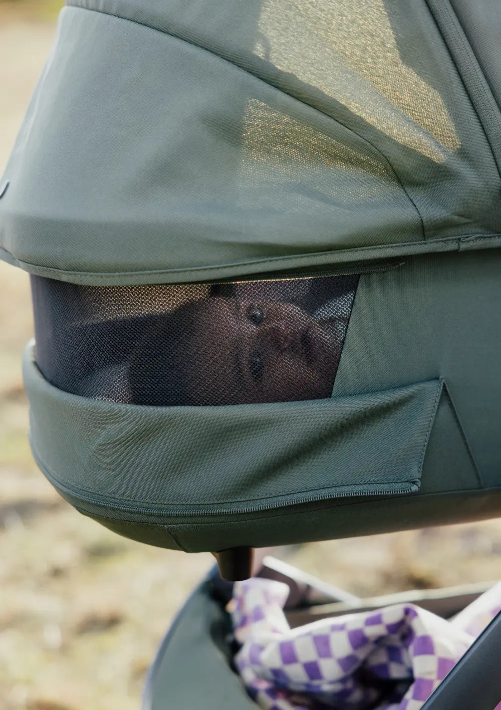 Baby schaut aus Belüftungsfenster der Joolz Babywanne 'Geo5' Forest Green
