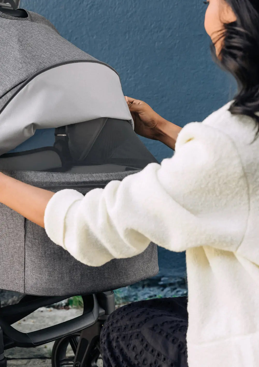 Eine Frau öffnet das Belüftungsfenster in der Babywanne des UPPAbaby Kinderwagen-Sets 'Vista V3' Greyson