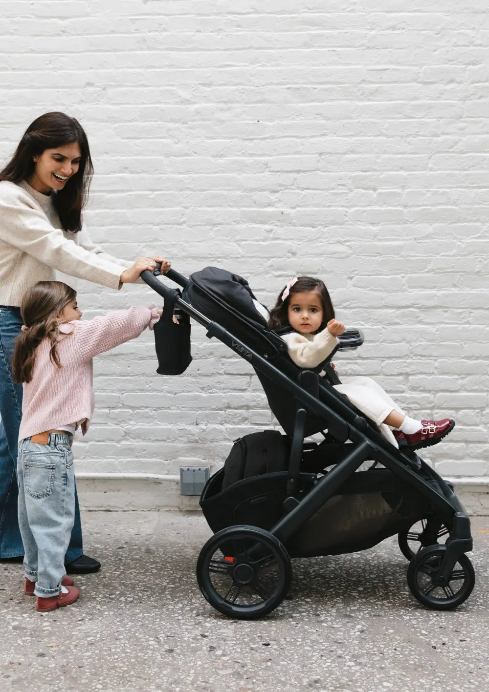 Frau mit zwei Mädchen beim Spaziergang, ein Kind sitzt im UPPAbaby Kinderwagen 'Vista V3' Jake
