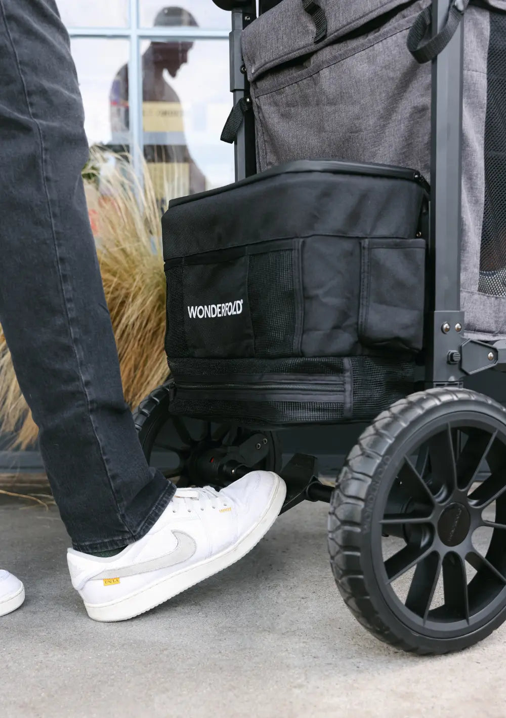 Nahaufnahme der Sicherheits-Fußbremse und der All-Terrain-Räder am WonderFold W6 Luxe Pro Kinderwagen.