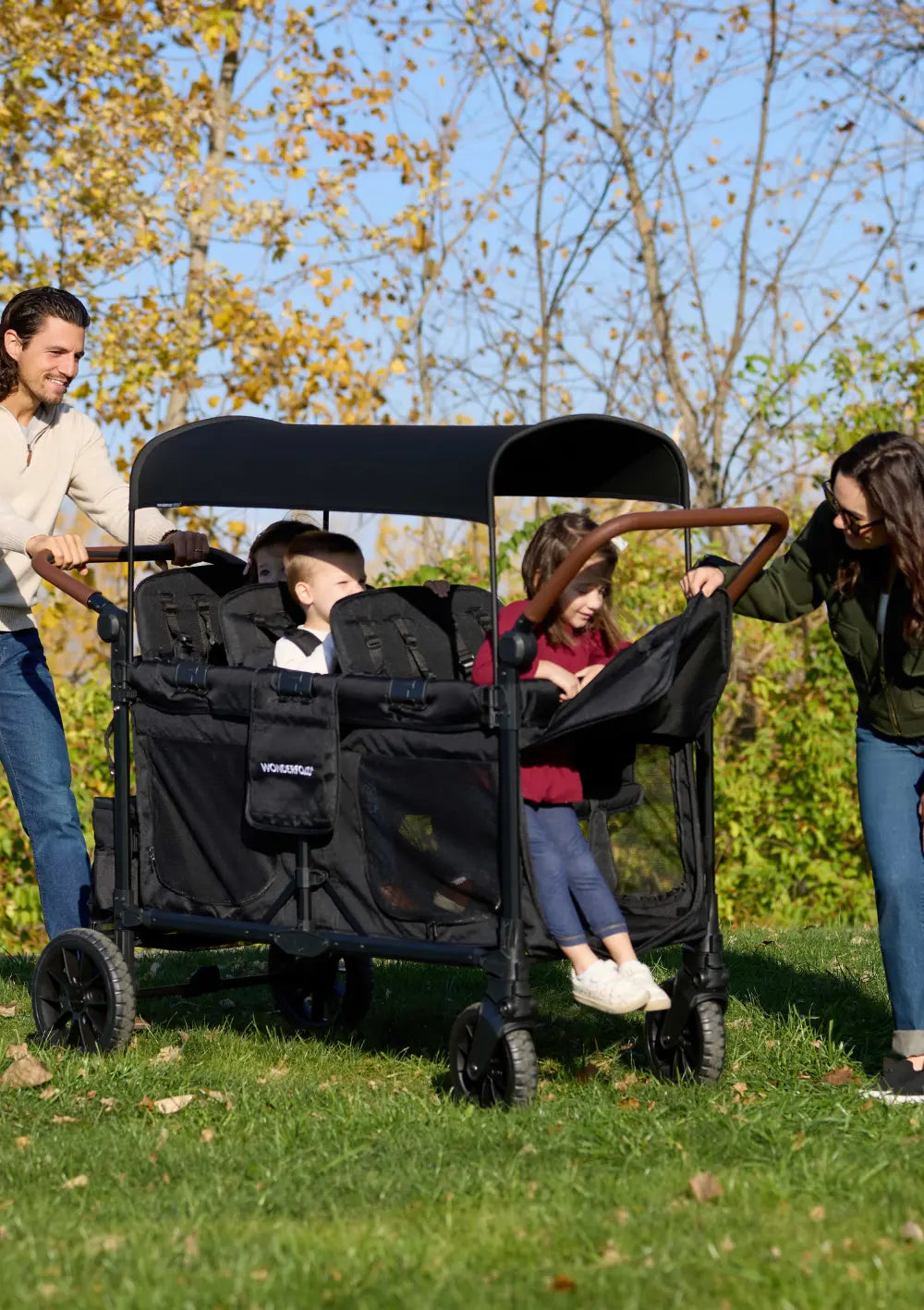 Kinder steigen durch die praktische Vorderklappe in den WonderFold W6 Luxe Pro Kinderwagen 6-Sitzer Jet Schwarz ein; idealer Transportwagen für mehrere Kids.