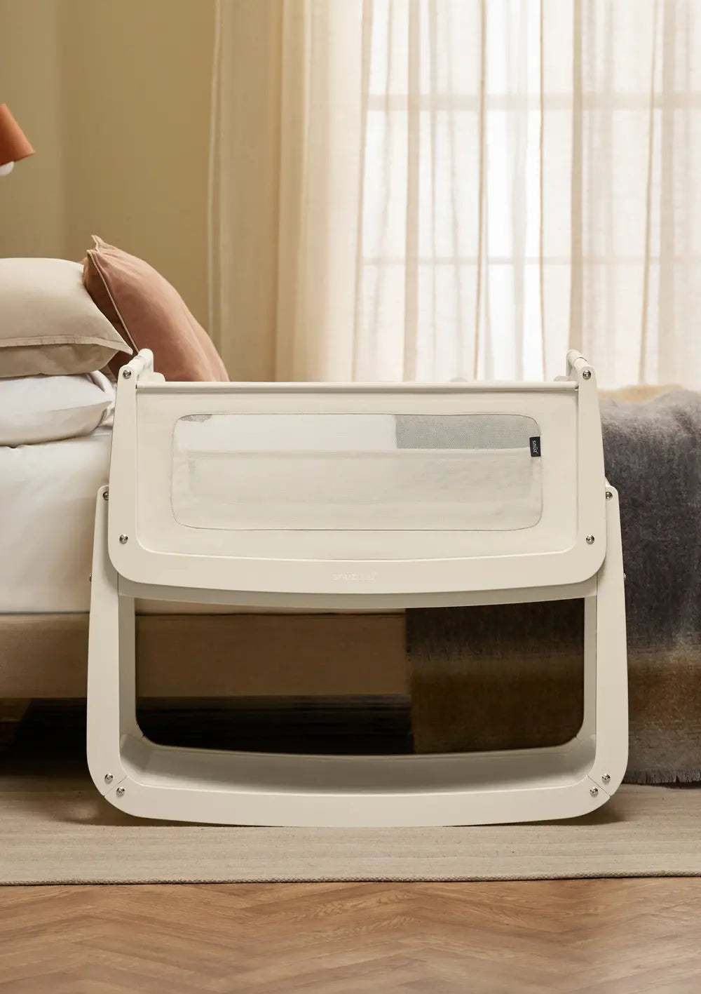 Sicheres Co-Sleeping im Elternschlafzimmer: Das cremefarbene Snüz Beistellbett SnüzPod 5 Cashmere steht passgenau und auf gleicher Höhe direkt neben dem großen Bett.