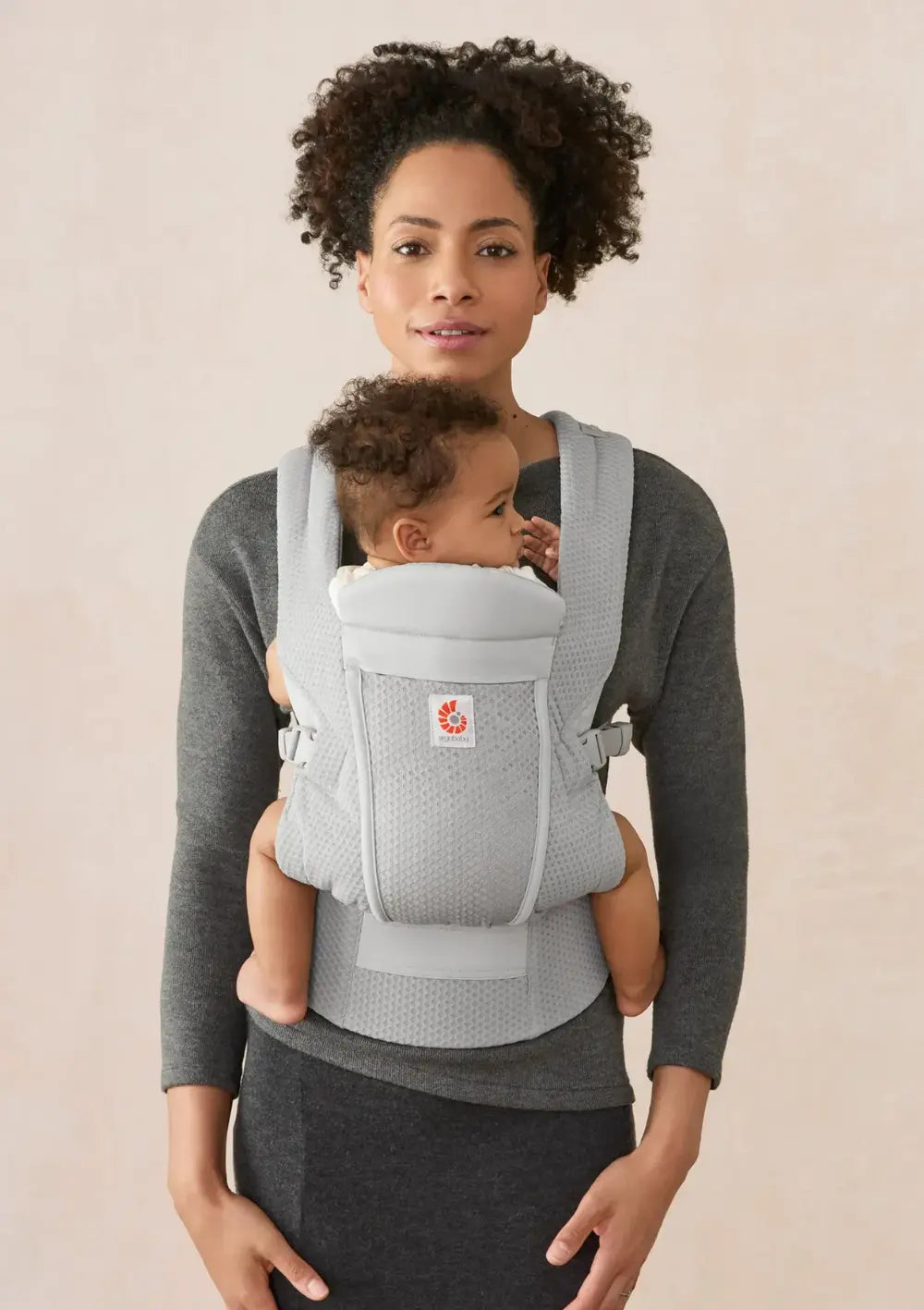 Frau trägt Baby in der Ergobaby Babytrage 'Omni Lite' Mesh Pearl Grey