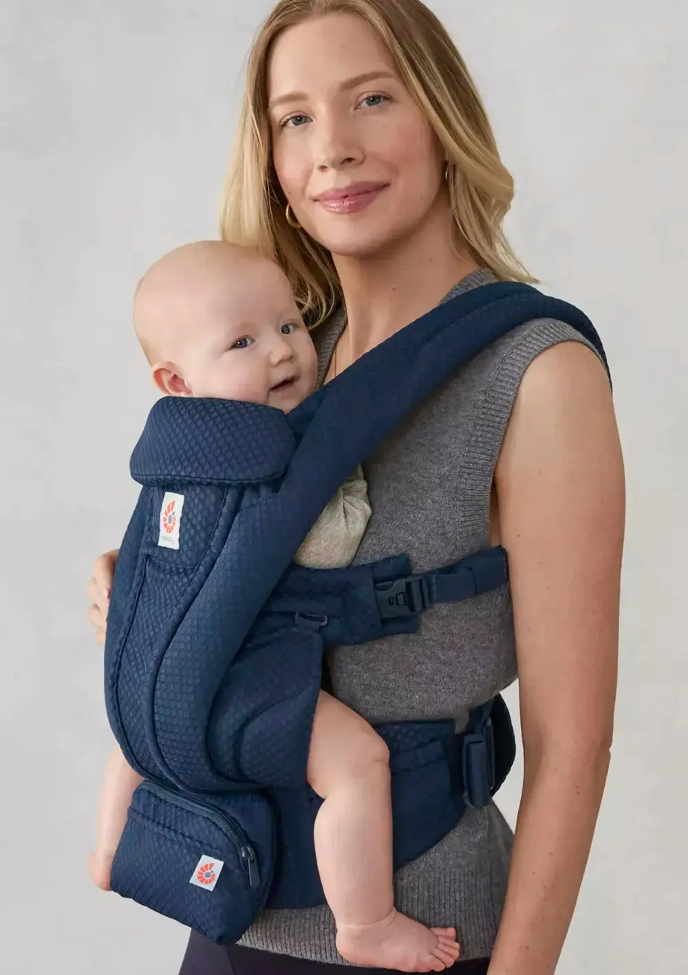 Frau trägt ihr Baby in der Ergobaby Babytrage 'Omni Deluxe' Mesh Midnight Blue (Fronttrageweise)