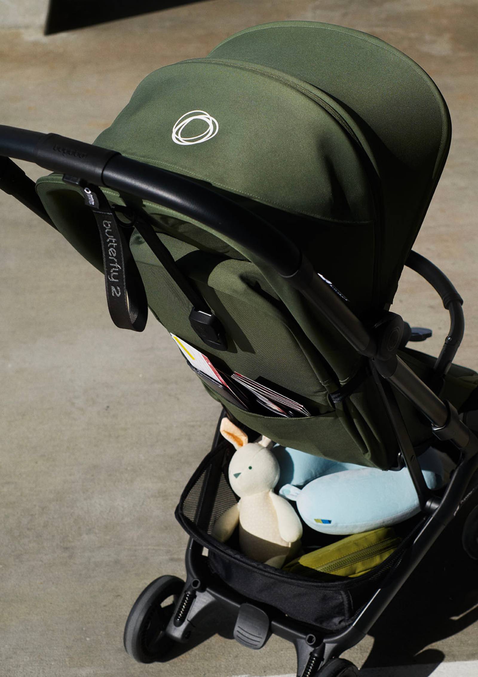 Bugaboo Buggy 'Butterfly 2' Waldgrün – Sitztasche und Einkaufskorb mit Essentials gefüllt