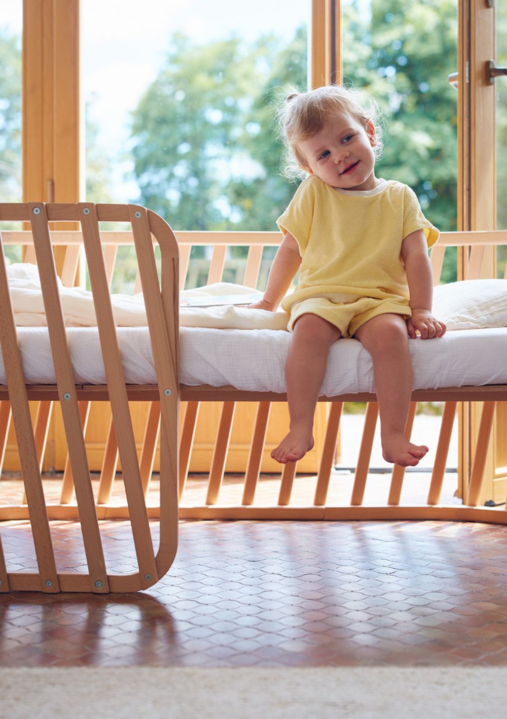 Kleines Mädchen sitzt auf Charlie Crane Chaiselongue 'Lugo' 140 x 70 cm