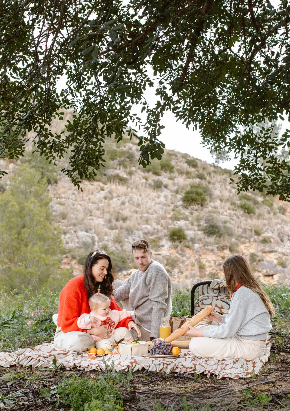 Familie beim Picknick auf Picknickdecke aus dem Joolz Travel-Set Buggy & Trage 'Aer2 x Wildride' Boho