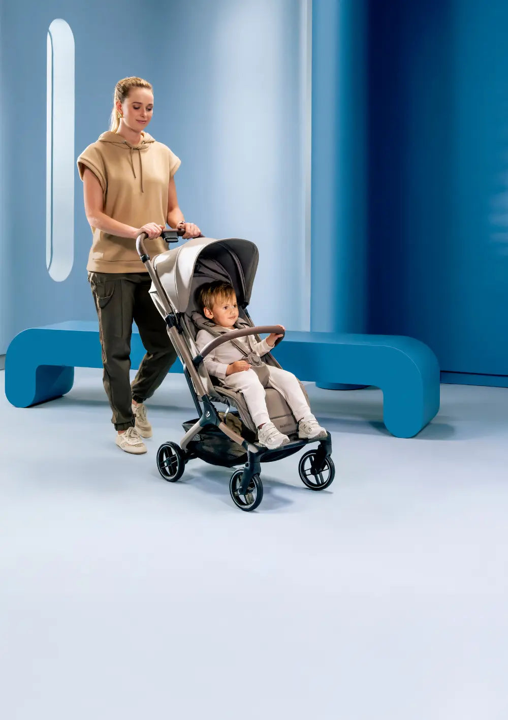 Frau schiebt Kind im Maxi-Cosi Buggy 'Oxford Cabin' Oak Truffle