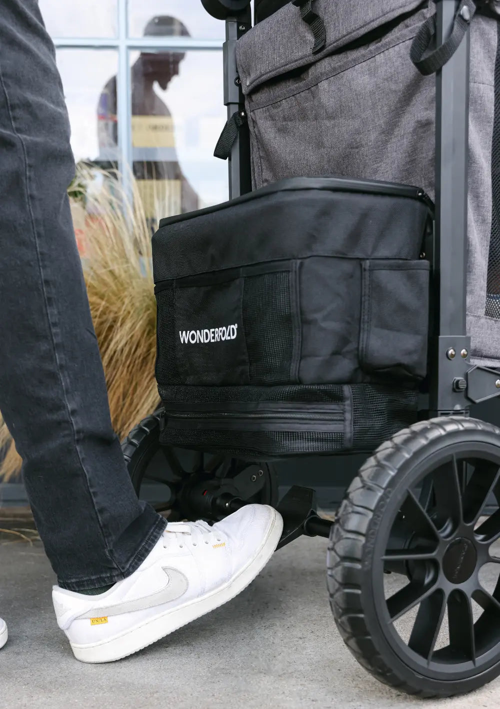 Detailansicht der einstufigen Fußbremse und der robusten XL-Reifen des WonderFold W2 Luxe Pro Kinderwagen 2-Sitzer.