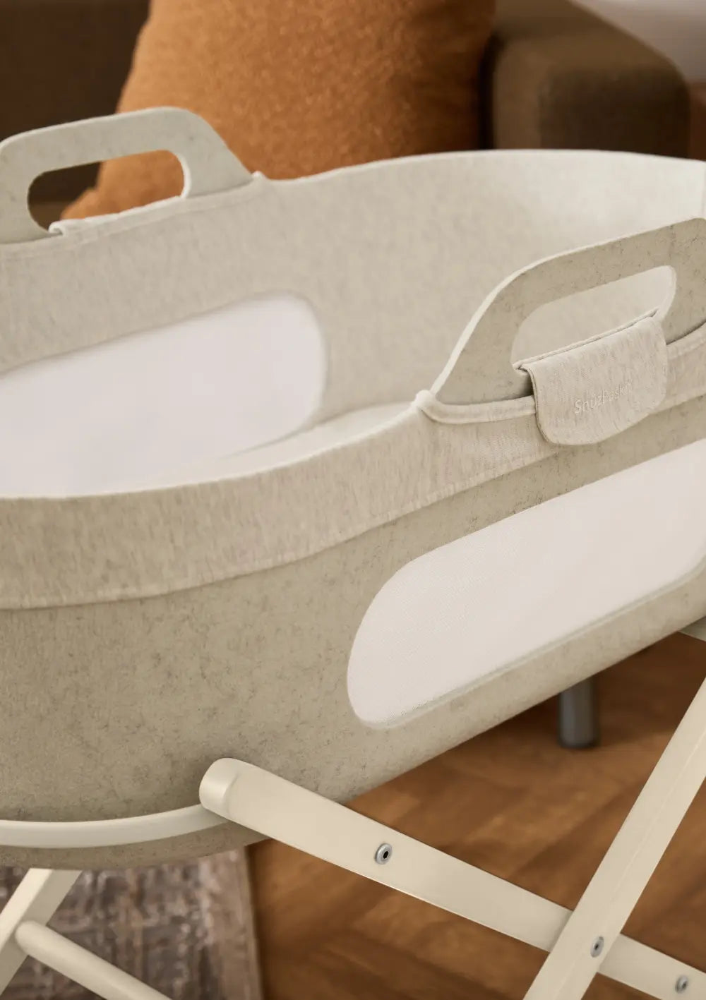 Detailansicht des Snüz Moseskorb inkl. Ständer SnüzBaskit Barley-Cashmere von oben; Fokus auf den ergonomischen Tragegriff, den weich gepolsterten Rand und das atmungsaktive Mesh-Fenster.