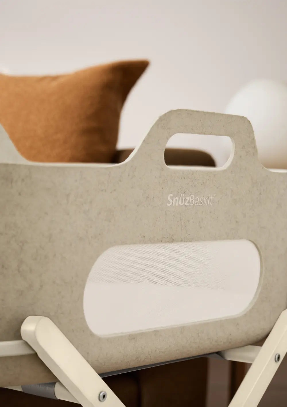 Detailansicht des Snüz Moseskorb inkl. Ständer SnüzBaskit Barley-Cashmere von oben; Fokus auf den ergonomischen Tragegriff, den weich gepolsterten Rand und das atmungsaktive Mesh-Fenster.