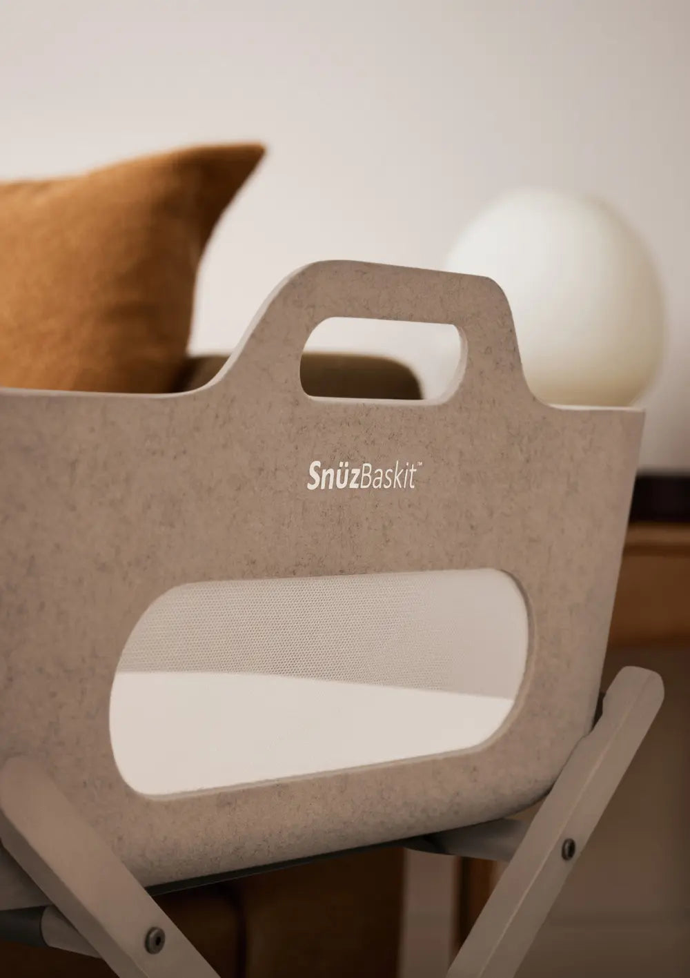Detailansicht des Snüz Moseskorb inkl. Ständer SnüzBaskit Mocha; Fokus auf den integrierten Tragegriff, das atmungsaktive Mesh-Sichtfenster und das geprägte Marken-Logo.