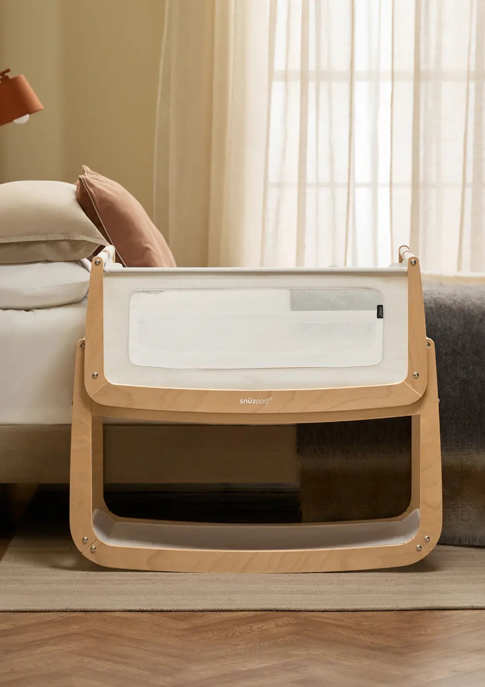 Das Snüz Beistellbett SnüzPod 5 Natur mit hellem Holzgestell steht passgenau und sicher direkt neben der Matratze des Elternbettes.
