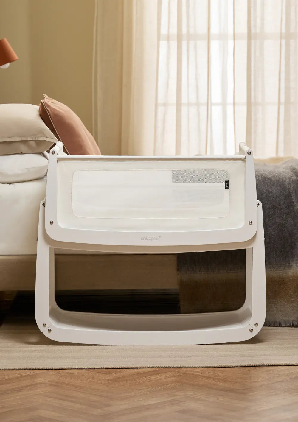 Das Snüz Beistellbett SnüzPod 5 Weiß mit weißem Holzgestell steht passgenau und sicher direkt neben der Matratze des Elternbettes.