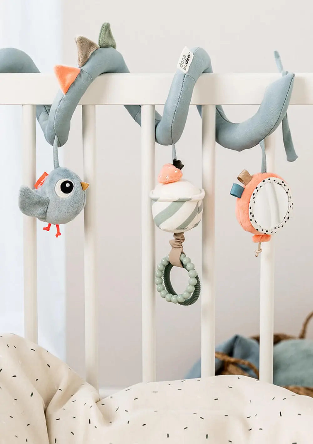 Done by Deer Activity Spirale 'Celebration' blau, befestigt am Gitter des Kinderbetts