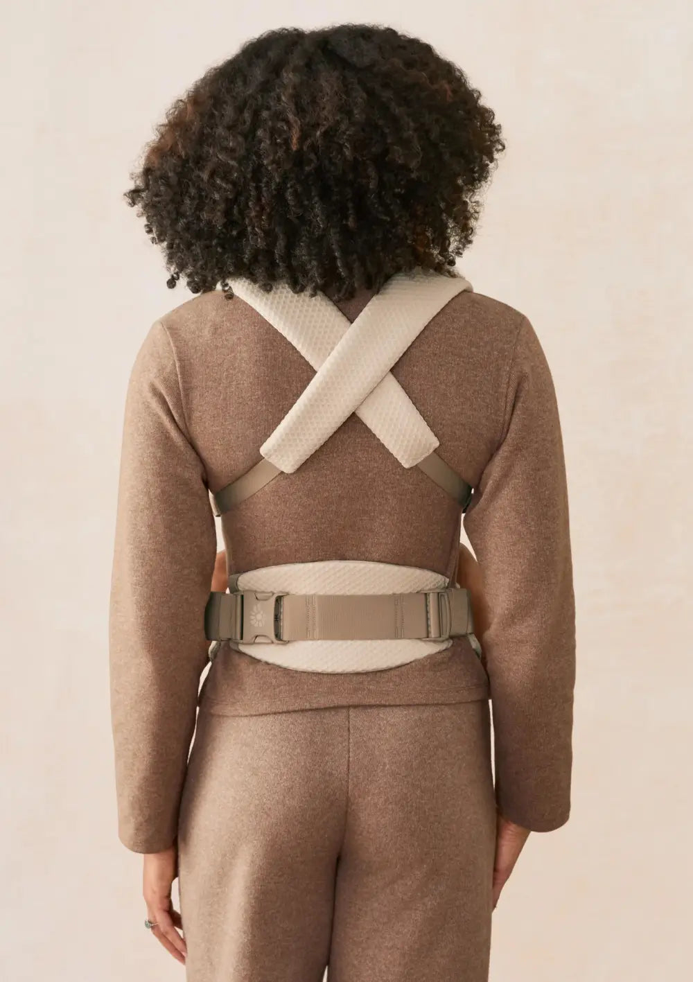 Frau trägt ihr Baby in der Ergobaby Babytrage 'Omni Lite' Mesh Natural Beige (Rückansicht)