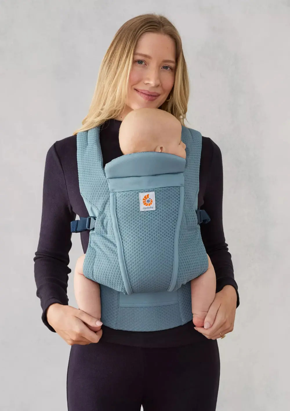 Frau trägt Baby in der Ergobaby Babytrage 'Omni Lite' Mesh Slate Blue