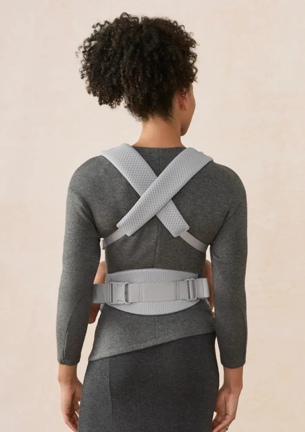 Frau trägt Baby in der Ergobaby Babytrage 'Omni Lite' Mesh Pearl Grey (Rückansicht)