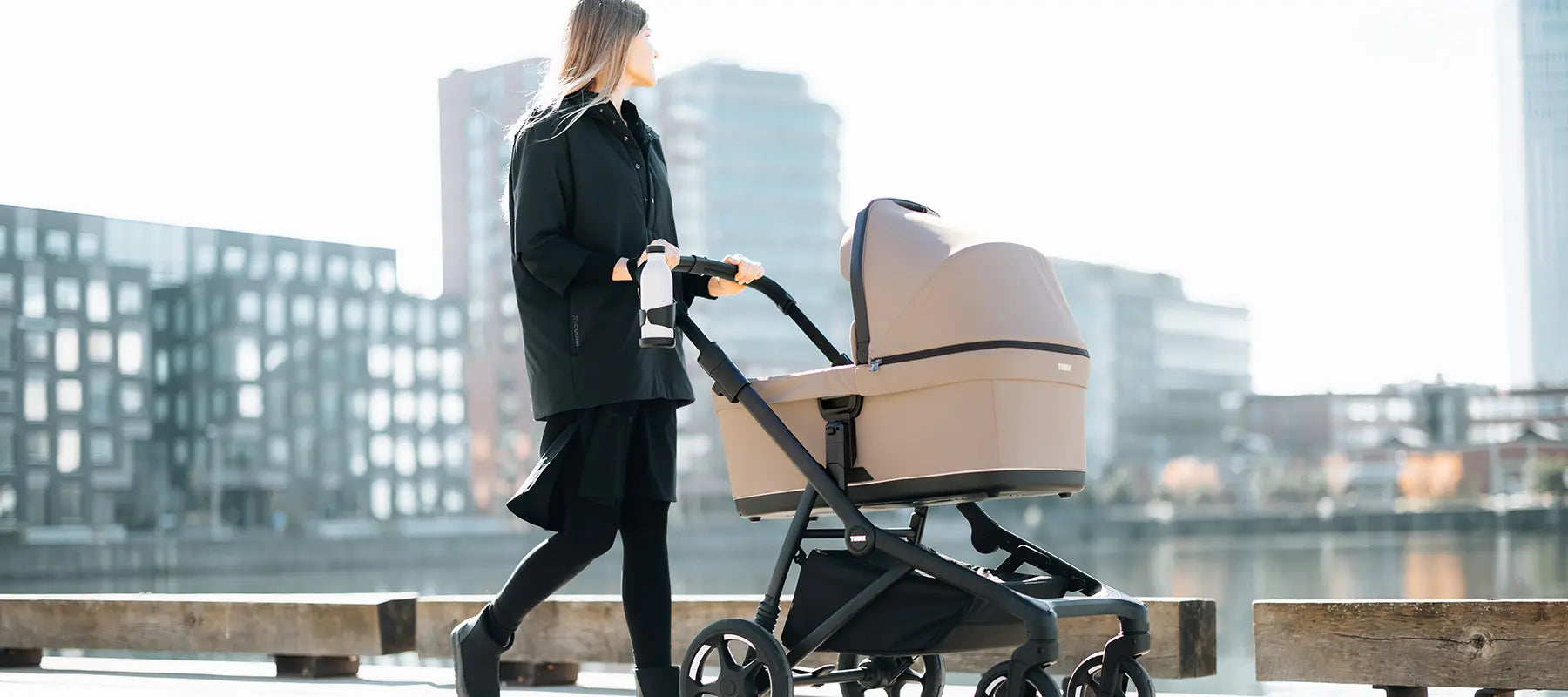 Thule Sleek Kinderwagen - im Bild: Frau mit Kinderwagen in der Stadt