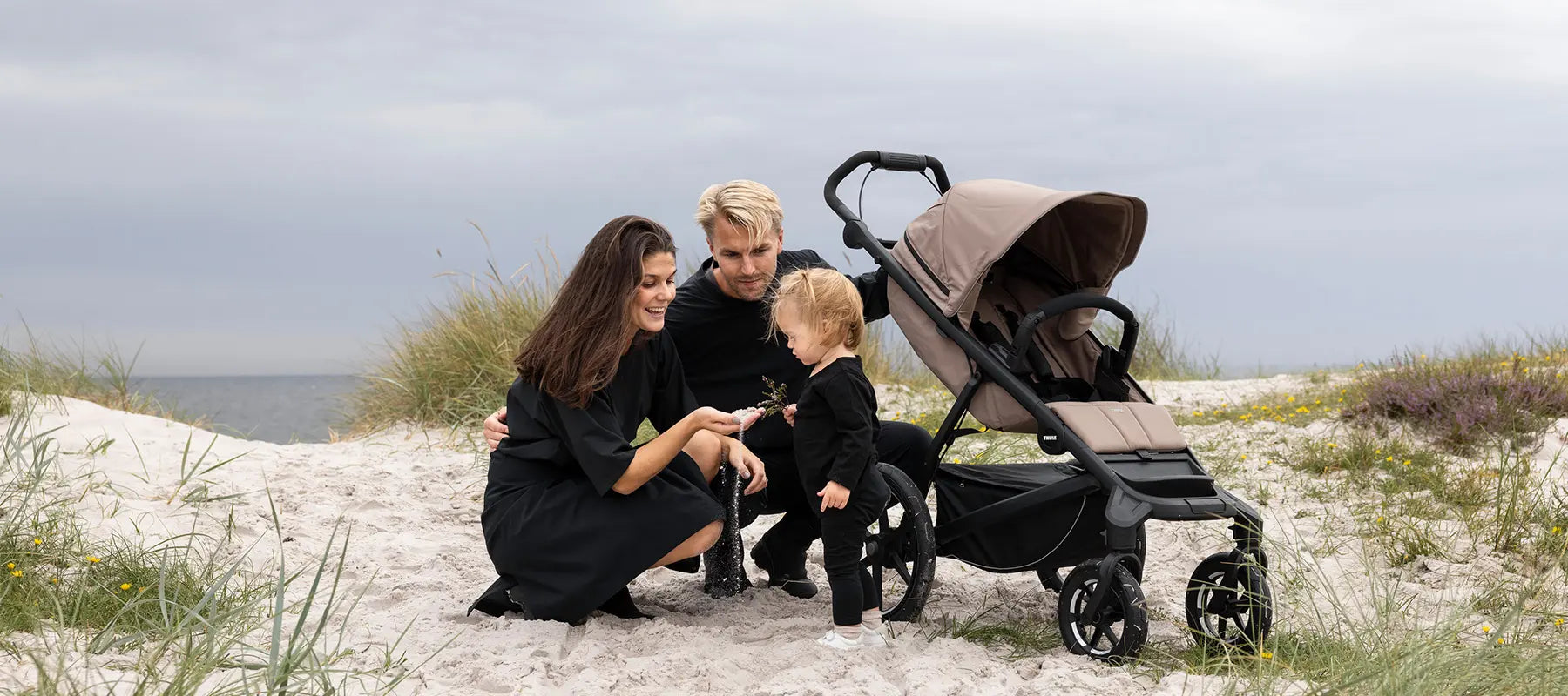 Thule Urban Glide - im Bild: Thule Urban Glide 4-wheel Kinderwagen mit Eltern und Kind am Strand